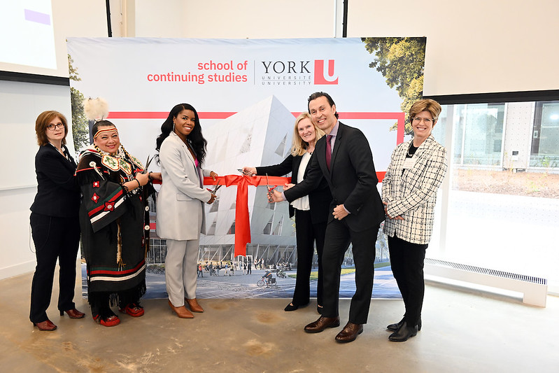 Ribbon cutting event to celebrate the opening of the School of Continuing Studies "Twisted Building." Pictured are Christine Brooks-Cappadocia, Interim AVP, School of Continuing Studies; Kim Wheatley, who blessed the land; Perdita Felicien, Canadian Olympian and keynote speaker; York University President and Vice-Chancellor Rhonda Lenton; Paul Tsaparis, Chair of the Board of Governors; and Tracey Taylor O'Reilly, Founder of the School of Continuing Studies.
