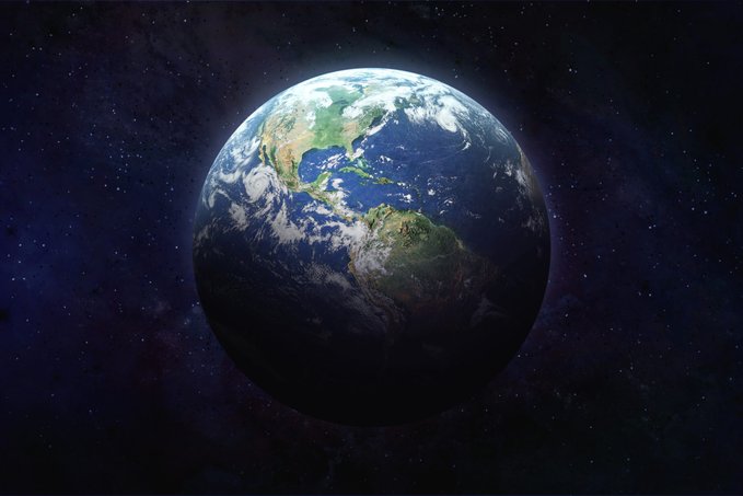 The planet earth in space is lit on the top half of the planet and dark on the bottom half.